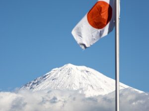 a japanese flag flying in front of a mountain
